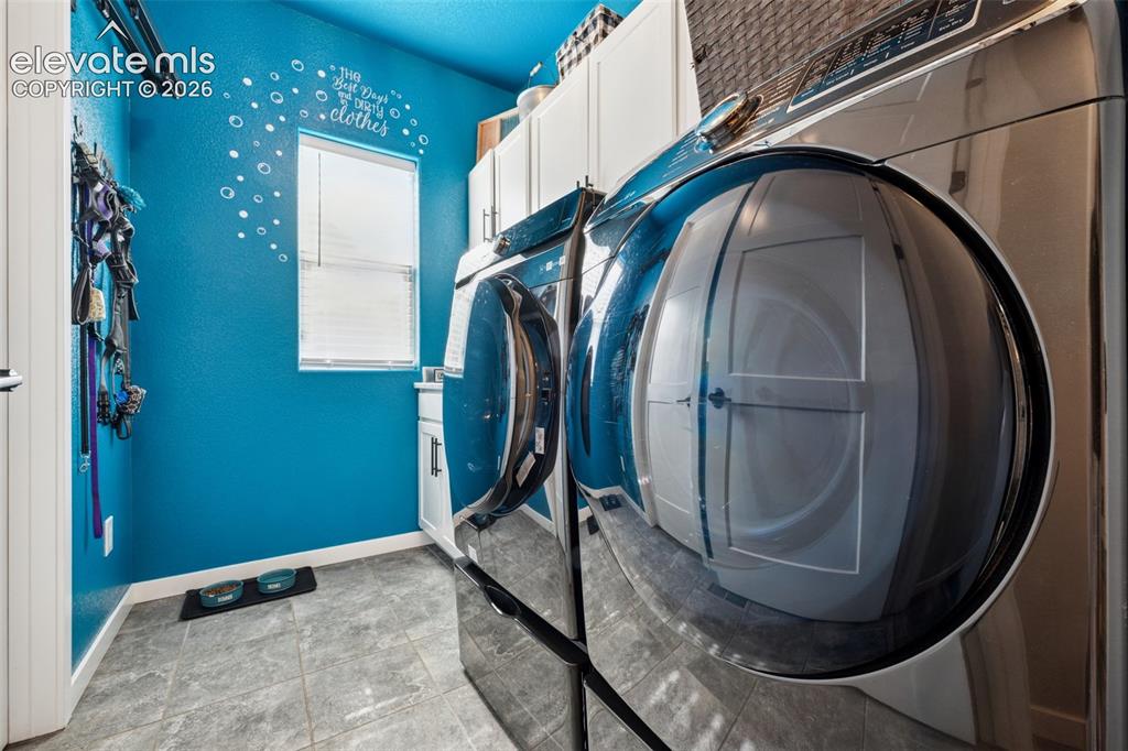 Image 23 of 40: Laundry room featuring cabinet space, sink, washer/dryer included; all on t