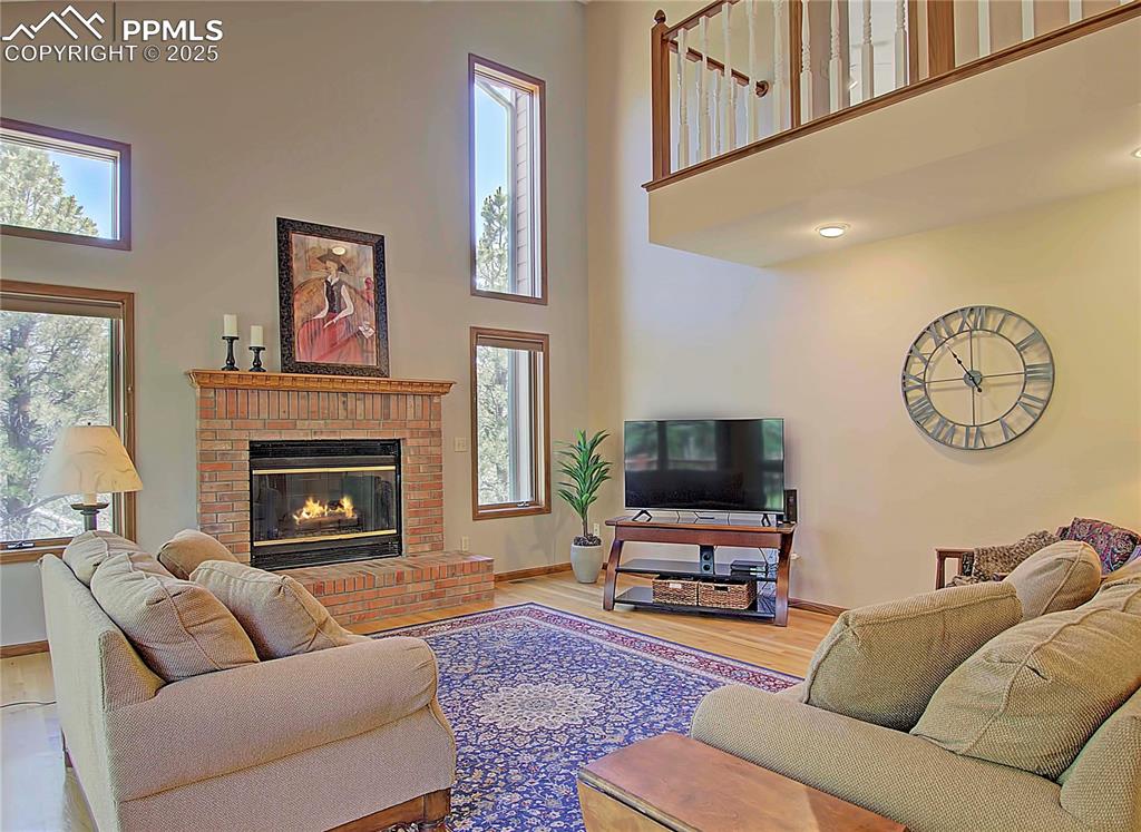 Image 18 of 40: Great room has vaulted ceiling, fan and gas fireplace
