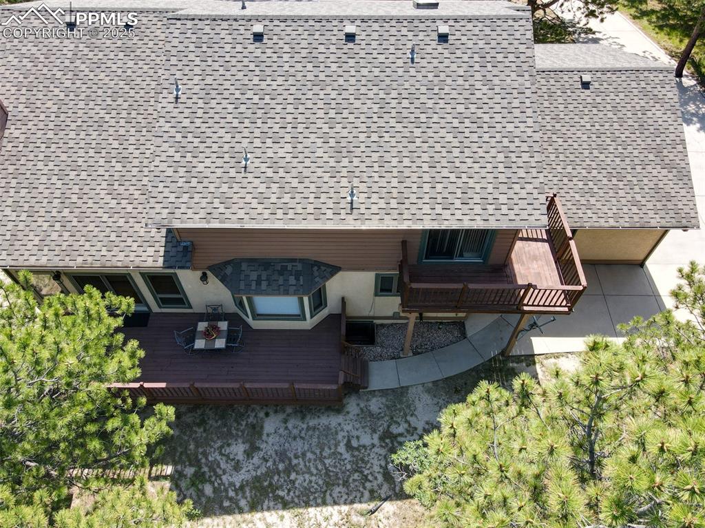 Image 36 of 40: View of the back of the home showing both decks and sidewalk from the extra