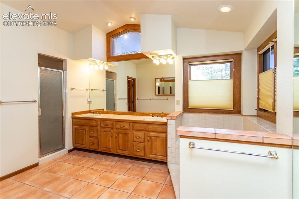 Image 16 of 40: Spacious bathroom featuring a dual vanity with a light wood-finish cabinet 