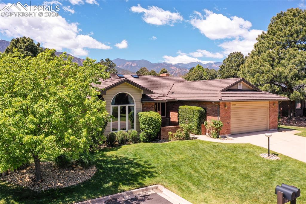Image 2 of 40: Ranch-style residence featuring a brick and siding exterior, arched window,