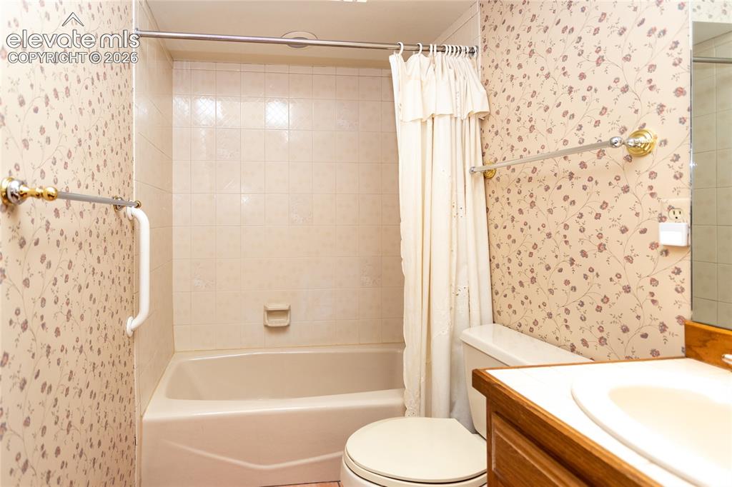 Image 24 of 40: Bathroom featuring a built-in bathtub, white subway tile surround, patterne