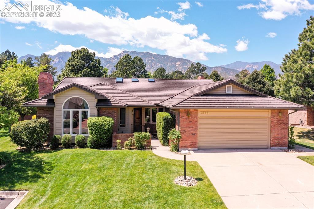 Image 3 of 40: Ranch-style residence featuring a brick and siding exterior, arched window,