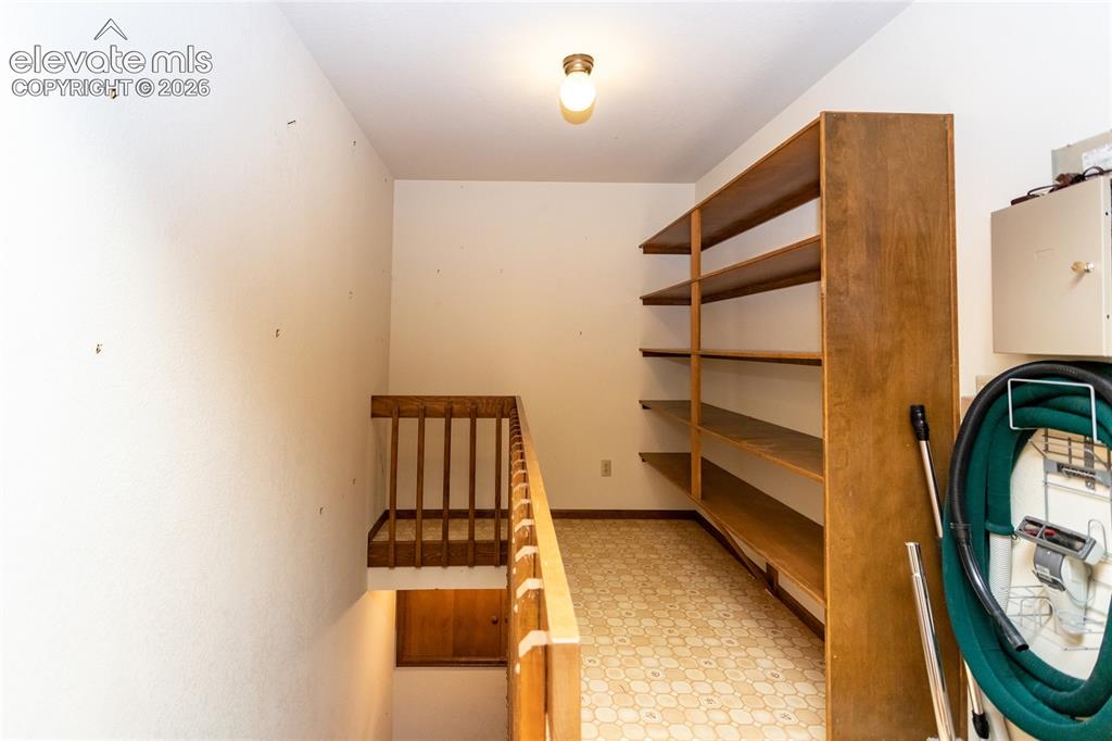 Image 32 of 40: Built-in wood shelving providing ample storage, a wood-finish staircase wit
