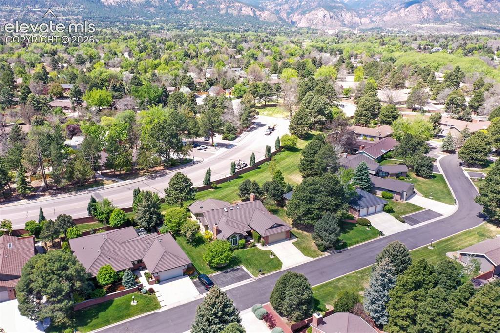 Image 37 of 40: Residential area with mature trees, paved streets, and mountain backdrop