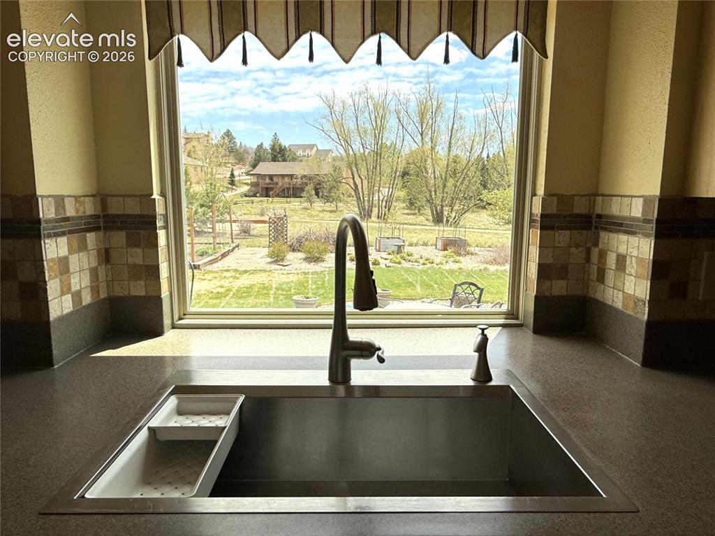 Image 11 of 50: Beautiful Stainless Sink Overlooks the Yard and Open Space