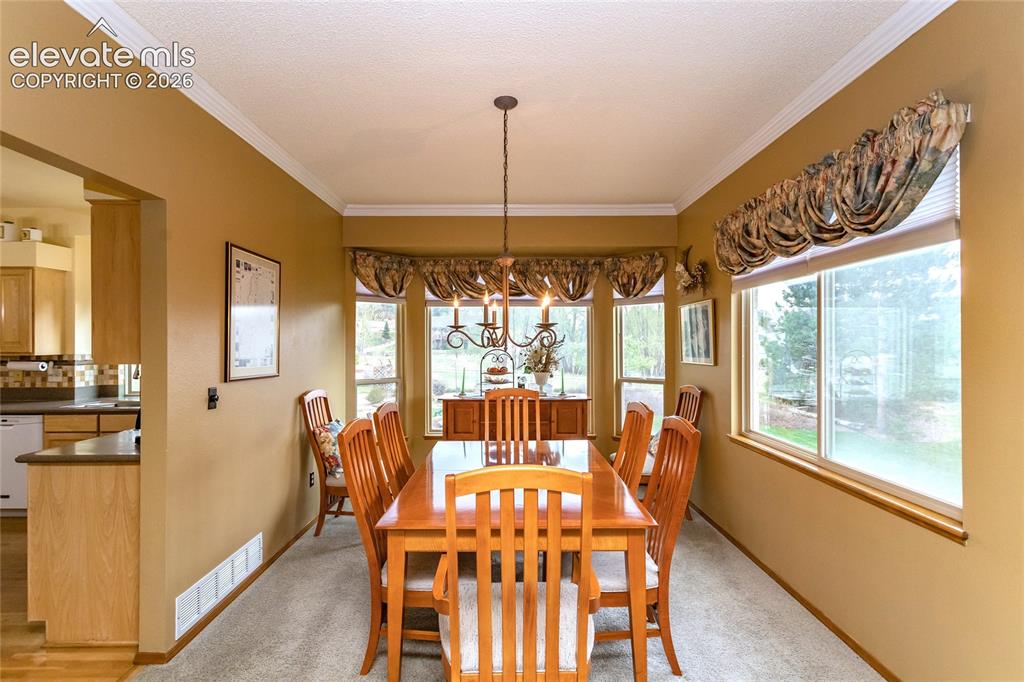 Image 13 of 50: Light and Bright formal Dining Room has a Bay Window and sits between the K