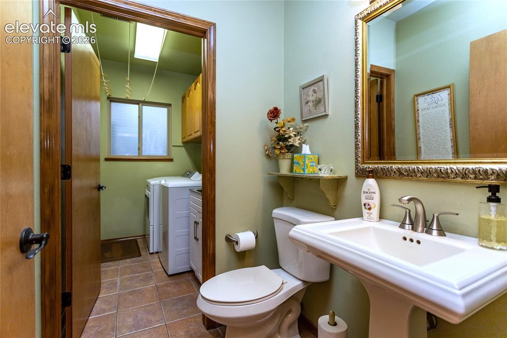 Image 16 of 50: Main Level Piowder Room w/ Adjoining Laundry Room