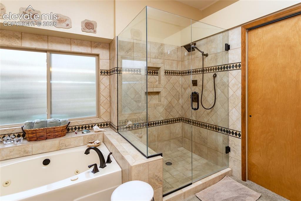 Image 21 of 50: Primary Bathroom Shower and Jetted Tub