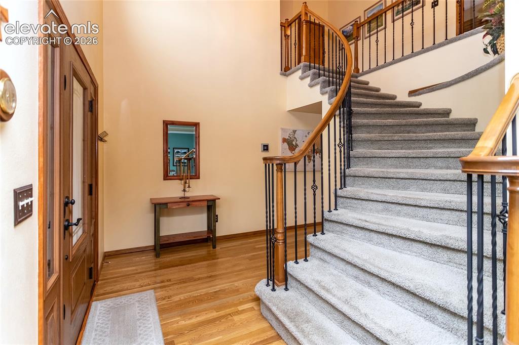 Image 4 of 50: Entry Foyer w/ Hardwood Floors and Massive, Curved Staircase