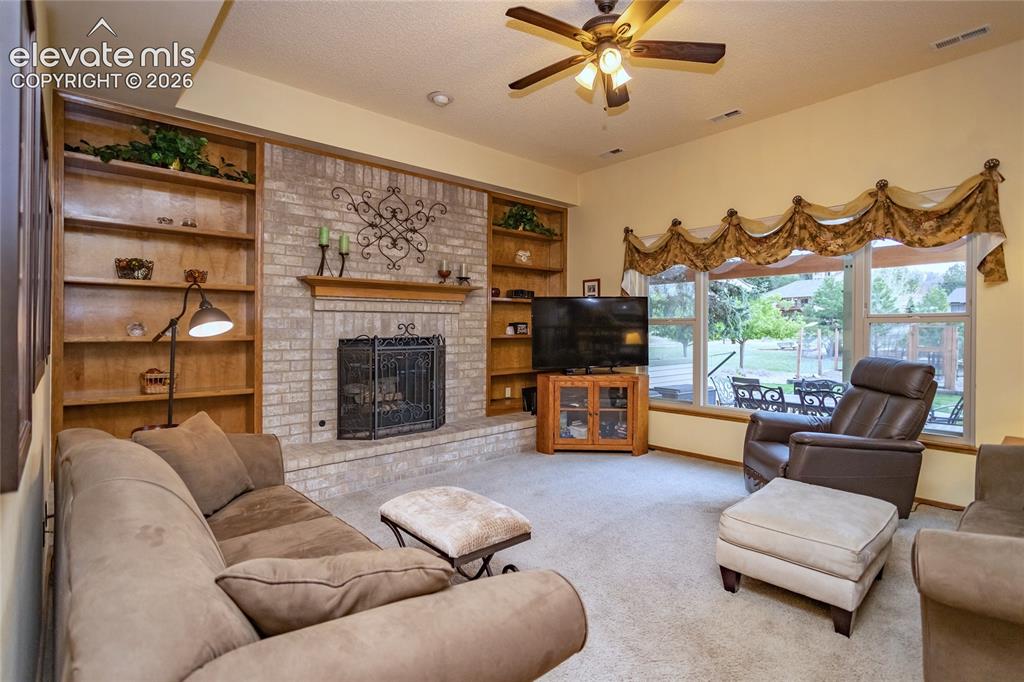 Image 5 of 50: Main Level Family Room w/ Gas Fireplace and Bookcase Built-ins