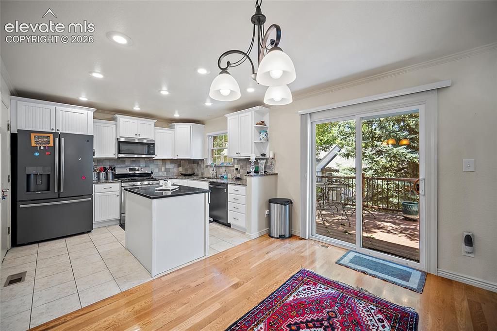 Image 13 of 48: Granite counter tops with Gas cooktop and walk out to the large deck.