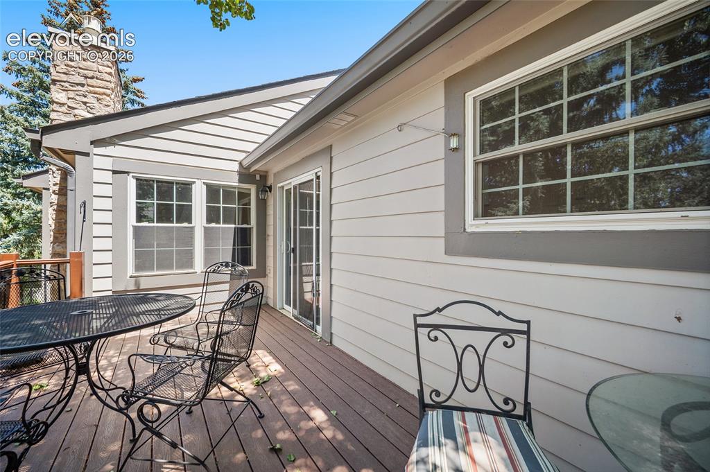 Image 8 of 48: Deck off of the kitchen overlooking grassy areas.