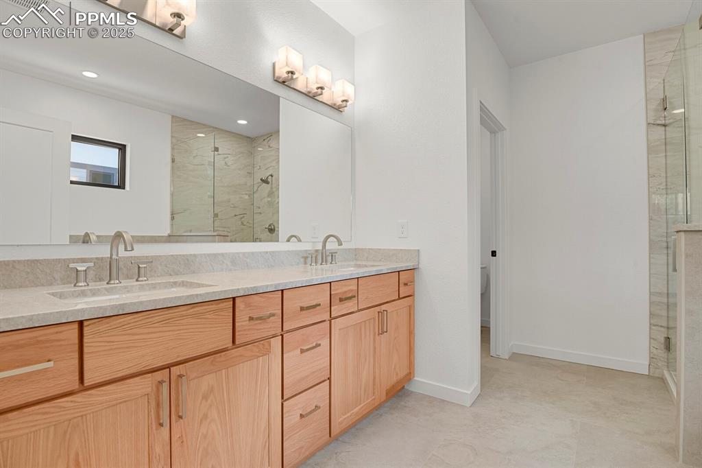 Image 11 of 49: Spa inspired primary bathroom with quartz counter and double vanity