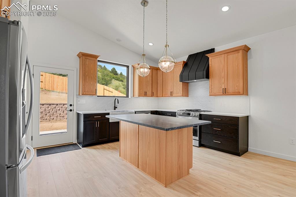 Image 26 of 49: Quartz counters, center island, farmhouse Carrara marble sink and backsplas