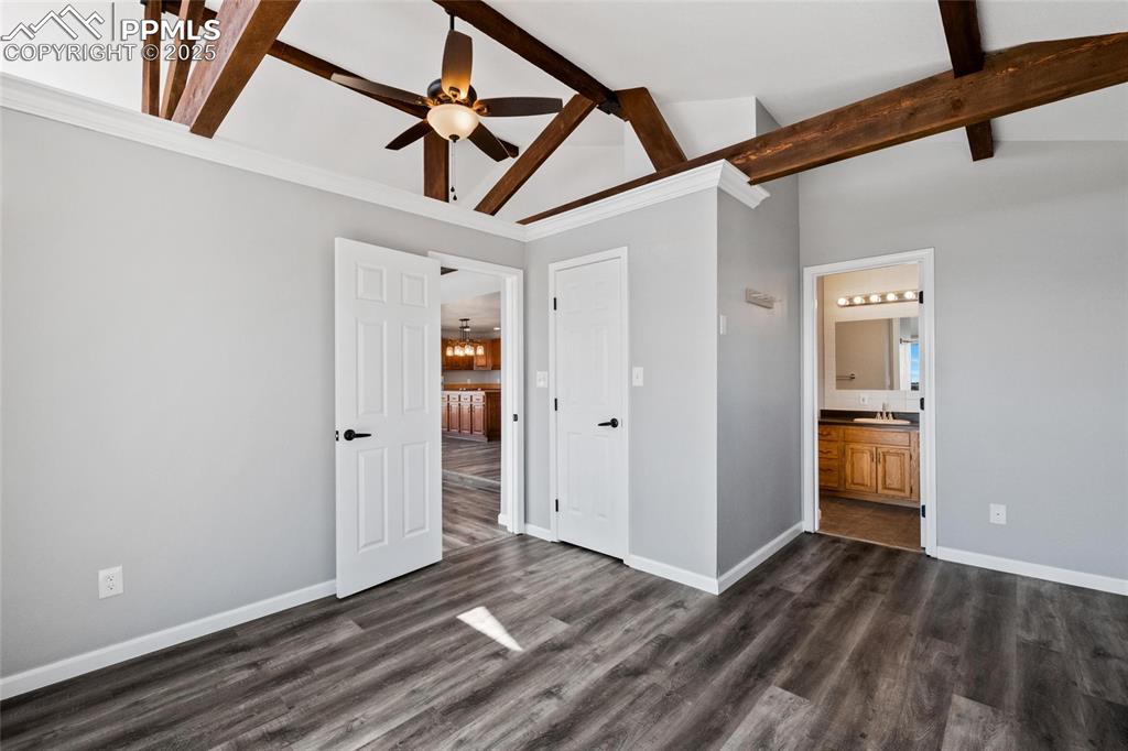 Image 13 of 38: Unfurnished bedroom featuring a sink, baseboards, dark wood-style floors, a
