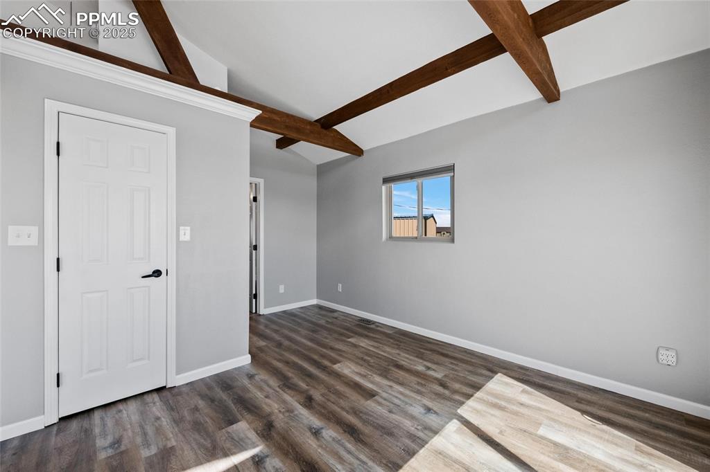 Image 14 of 38: Unfurnished room featuring baseboards and dark wood-style flooring