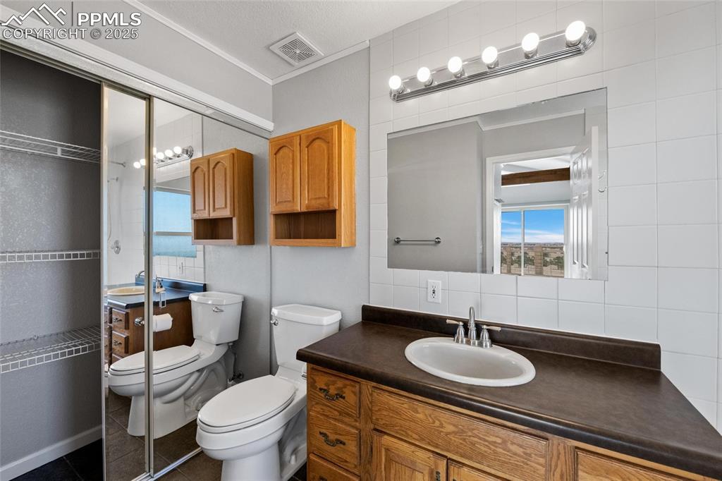 Image 15 of 38: Bathroom featuring toilet, vanity, a shower, tile patterned flooring, and t