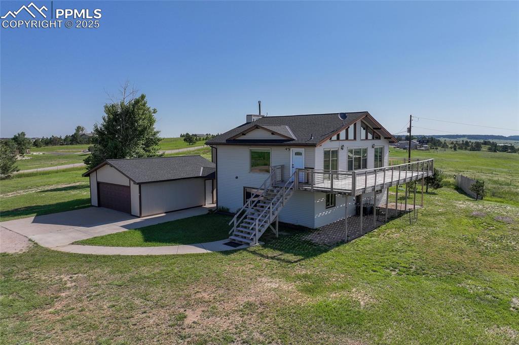 Image 27 of 38: Rear view of property with stairway, driveway, a wooden deck, an outdoor st