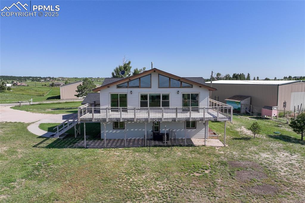 Image 28 of 38: Back of house featuring a wooden deck, a yard, stairway, and a patio area