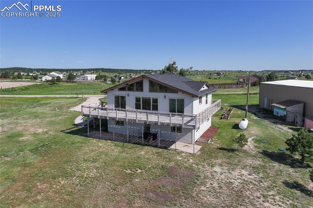 Image 29 of 38: Rear view of property with a wooden deck and a lawn