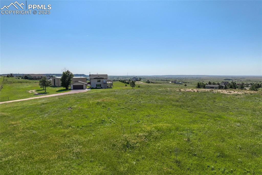 Image 38 of 38: View of green lawn featuring concrete driveway and a view of countryside