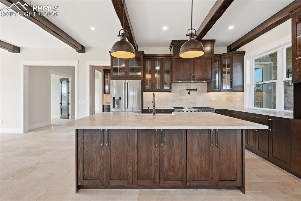 Image 11 of 45: Kitchen featuring dark wood finish cabinets, stainless steel fridge with ic