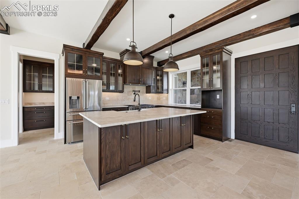 Image 15 of 45: Kitchen featuring glass fronted cabinets, dark wood finish cabinetry, high