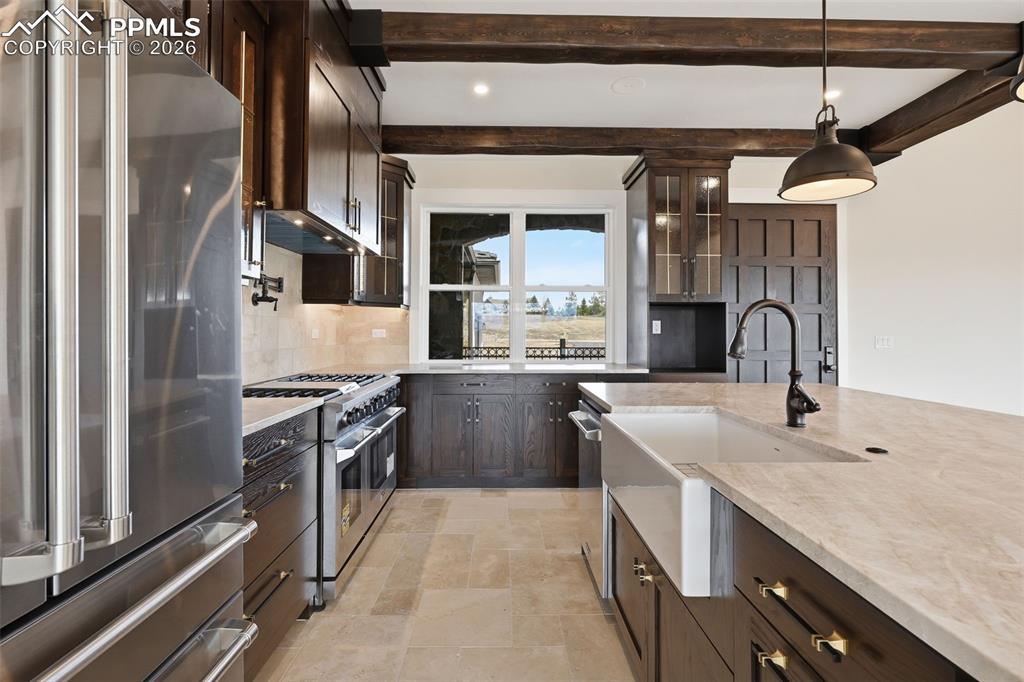 Image 16 of 45: Kitchen with dark wood finish cabinets, high end appliances, glass insert c