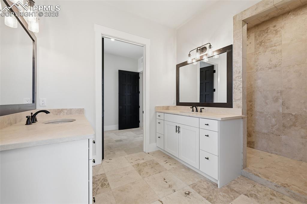 Image 22 of 45: Full bath off Master Bedroom featuring two vanities and a walk-in shower.