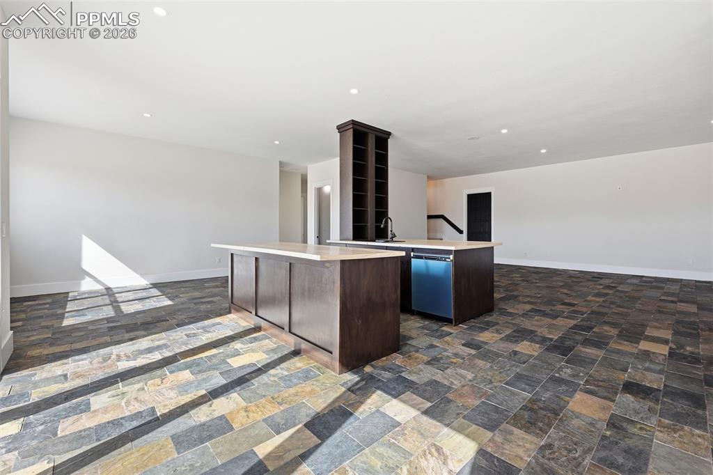 Image 26 of 45: Lower Level Famiy Room featuring light countertops, dark wood finish cabin