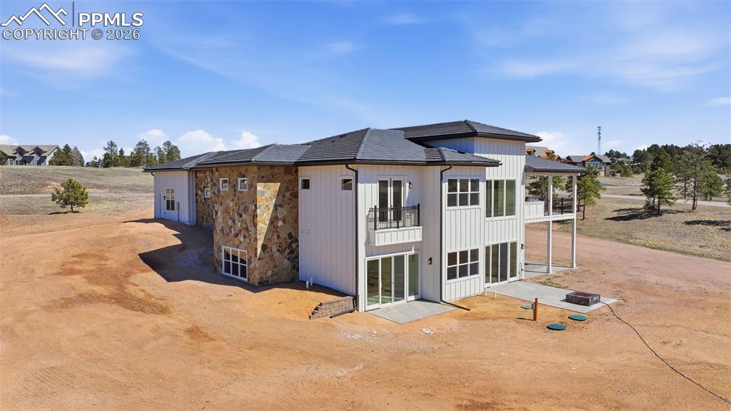 Image 3 of 45: Rear view of house featuring a balcony and a patio. Note: Romeo & Juliette