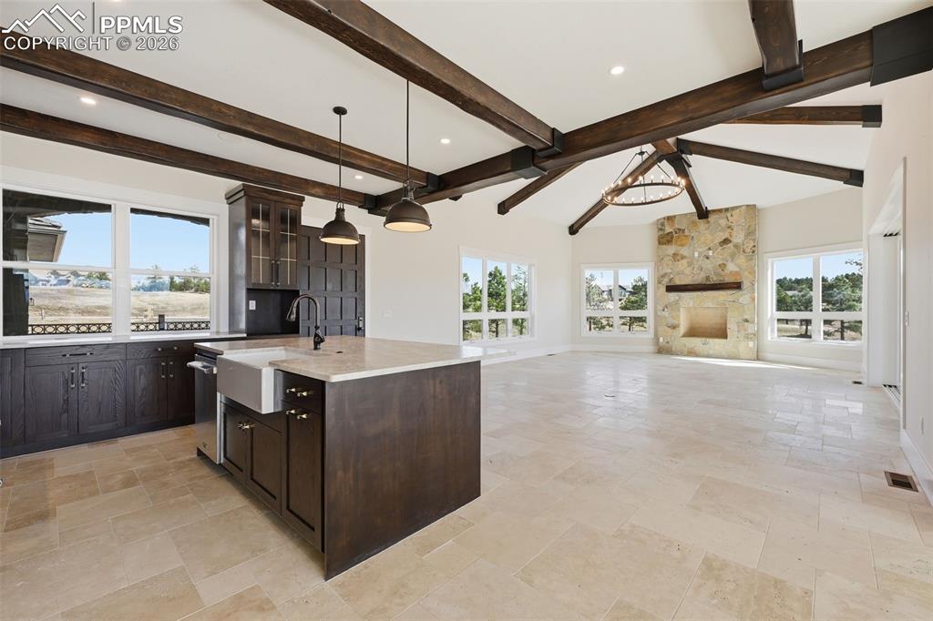 Image 8 of 45: Kitchen with dark wood finish cabinets, a kitchen island with sink, open fl