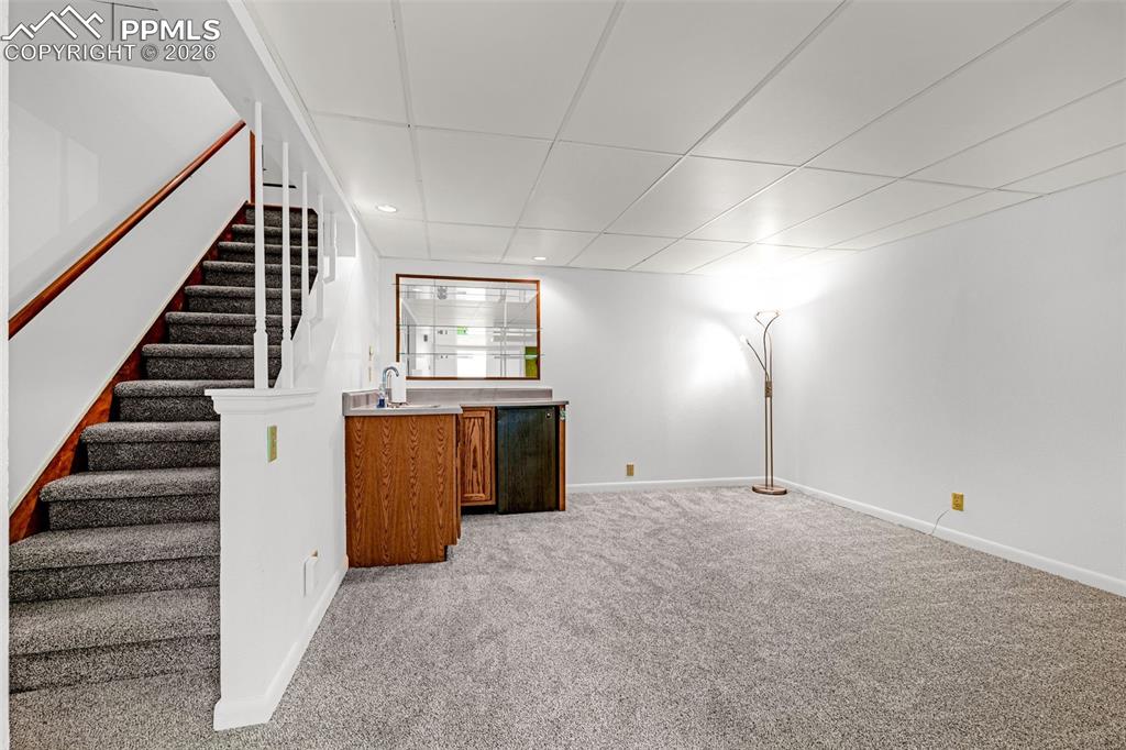 Image 20 of 44: This versatile space offers a wet bar with mini fridge