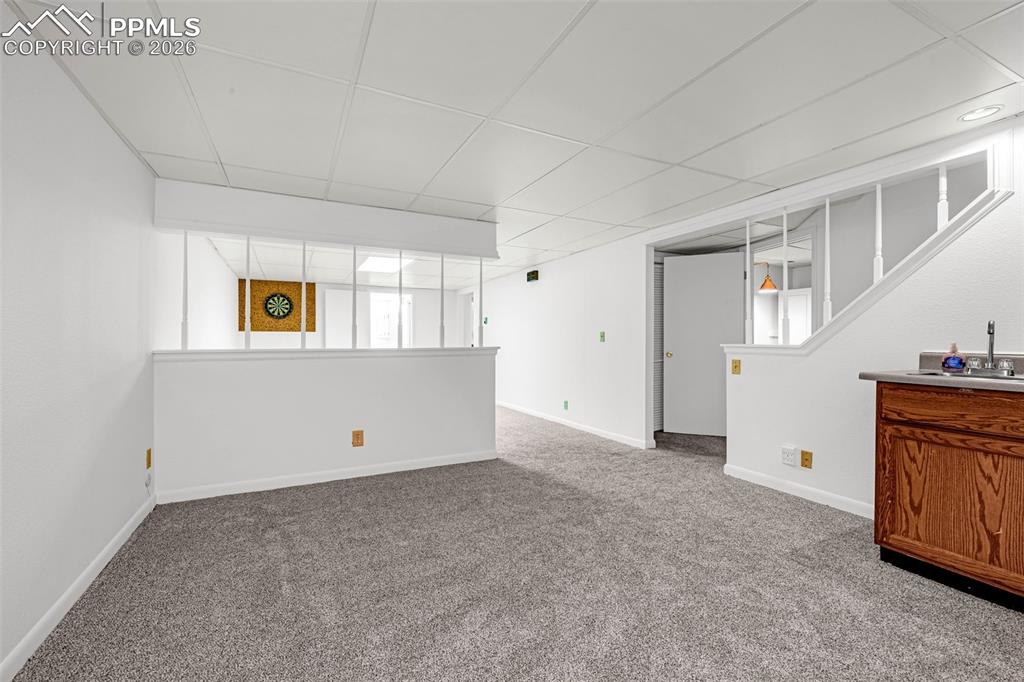 Image 21 of 44: Basement family room offering plenty of options and featuring a wet bar
