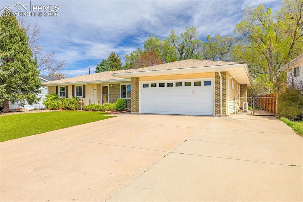 Image 28 of 44: The property features a two-car garage with a white door, a paved driveway,