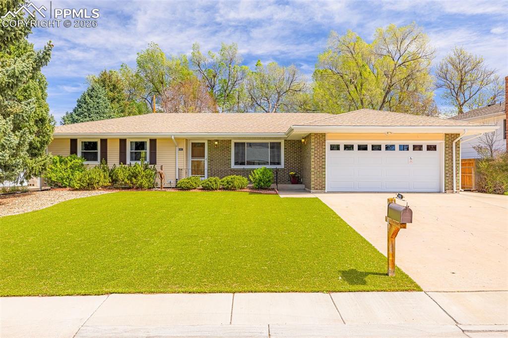 Image 29 of 44: The property features an artificial lawn, a spacious driveway, and an attac