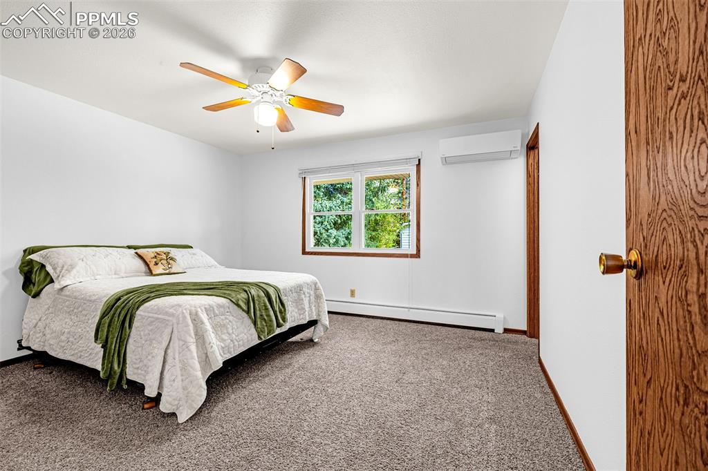 Image 5 of 44: Spacious primary bedroom with a ceiling fan with integrated lighting
