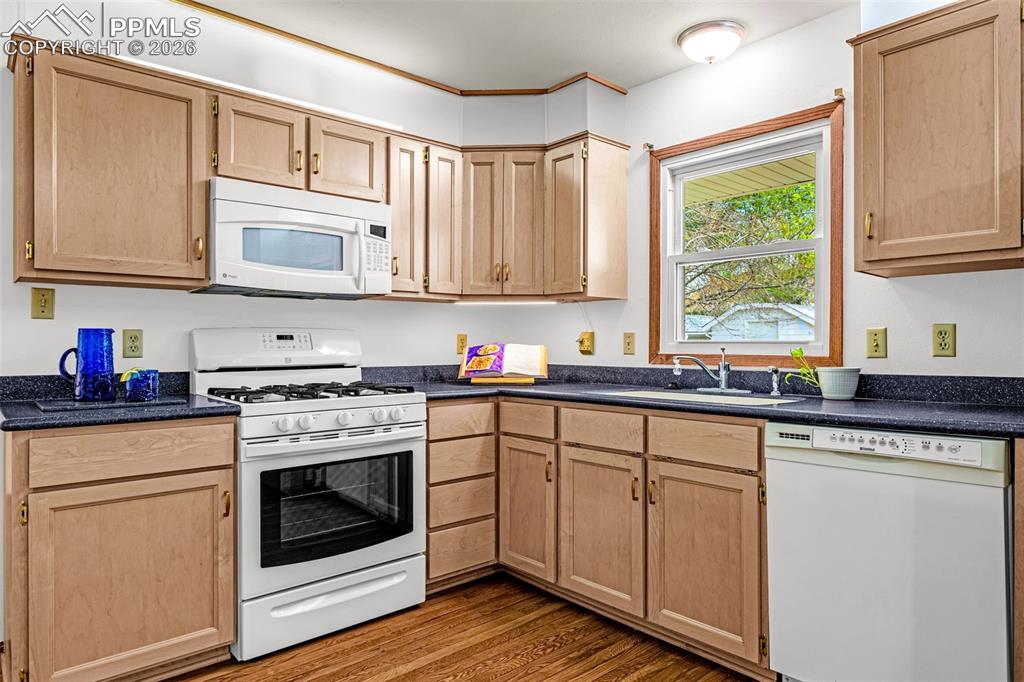 Image 9 of 44: The kitchen features wood cabinetry and a gas range with microwave