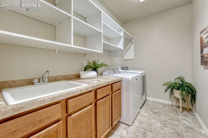 Image 18 of 41: Large Main level laundry room with a sink and plenty of storage!