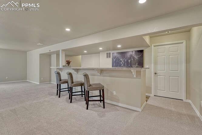Image 22 of 41: Basement bar area leading into the utility/storage space