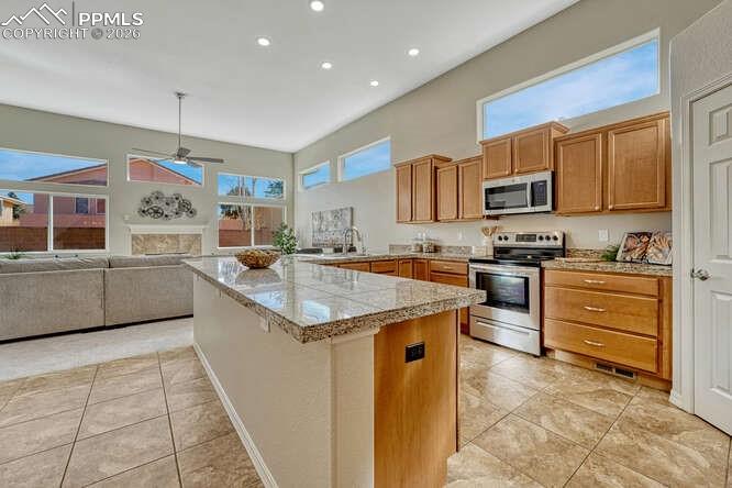 Image 33 of 41: Open concept kitchen/dining area with tile flooring & walk in pantry