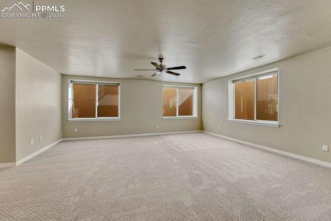 Image 36 of 41: Huge Basement Family room with large windows and fan