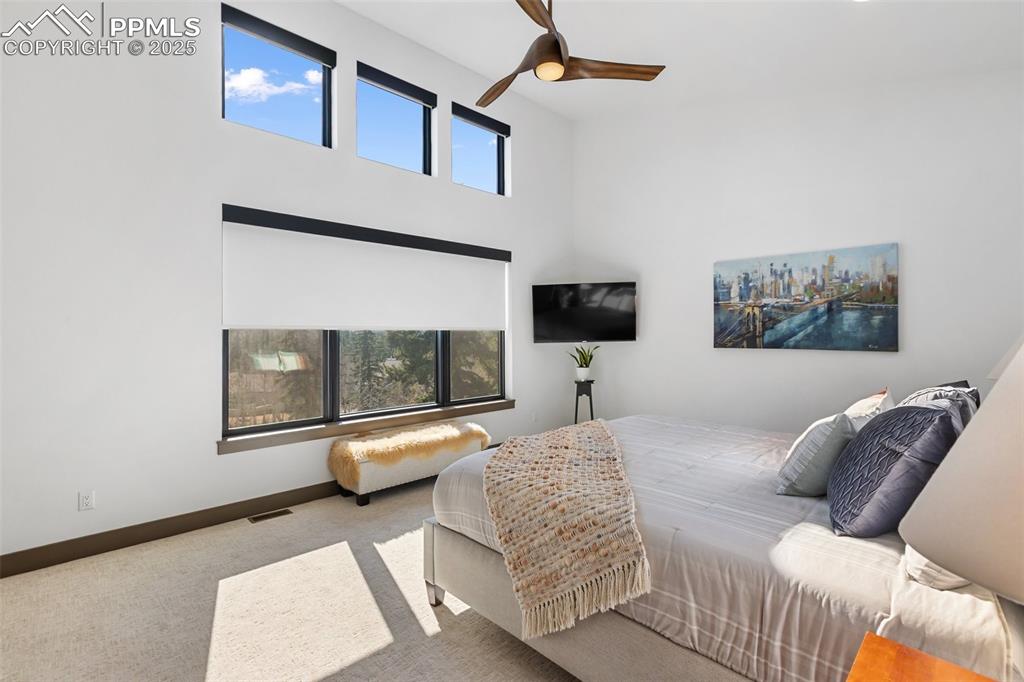 Image 14 of 48: Gorgeous Pikes Peak views from this primary suite bedroom with automatic, p