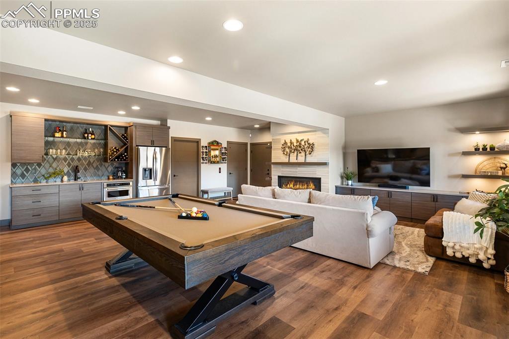 Image 25 of 48: Lower level family room with walk out, wet bar, fireplace. 