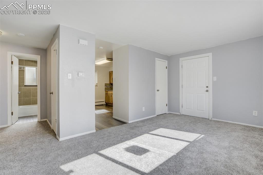 Image 12 of 42: Unfurnished bedroom featuring ensuite bathroom, light colored carpet, and b
