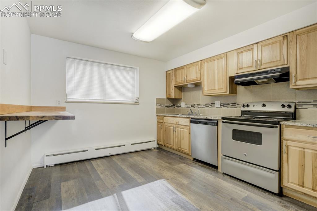 Image 13 of 42: Kitchen with stainless steel appliances, light wood finish cabinets, decora