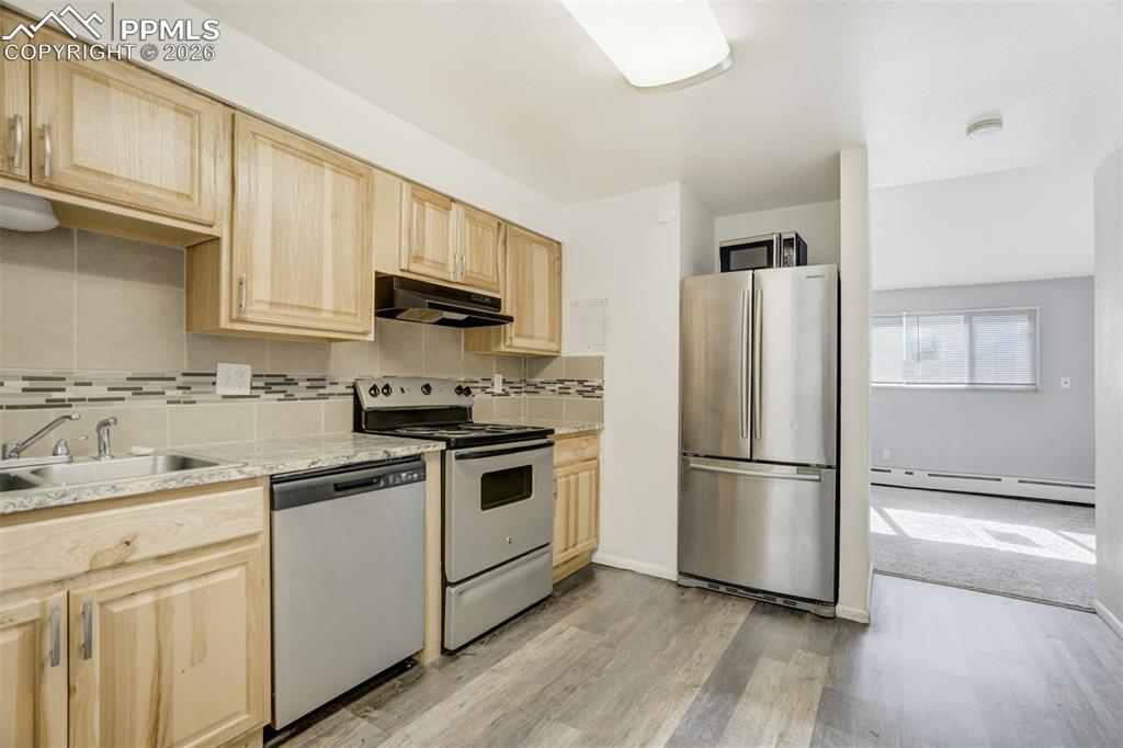 Image 14 of 42: Kitchen featuring light wood finish cabinetry, stainless steel appliances, 