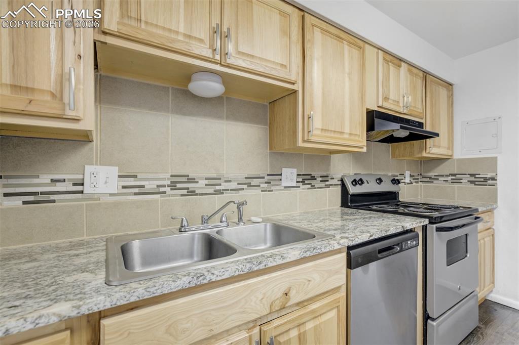 Image 15 of 42: Kitchen with light wood finish cabinets, stainless steel appliances, light 