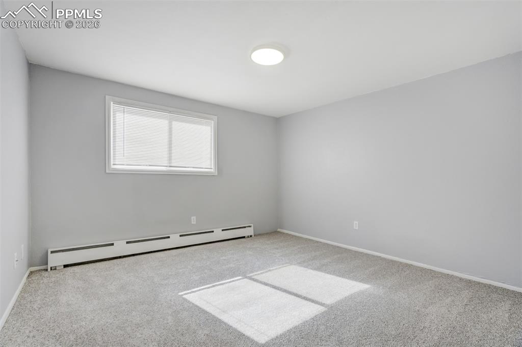 Image 20 of 42: Spare room with a baseboard heating unit and carpet flooring